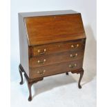 An Edwardian mahogany and inlaid bureau with fall-front enclosing fitted interior above three long