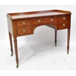 An early 19th century mahogany five drawer kneehole writing table/wash stand with three-quarter