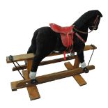 A 20th century plush rocking horse with red leather saddle, length 137cm.