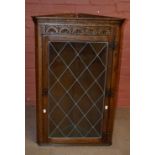 A reproduction oak wall corner cupboard with single glazed door, height 99cm, width 64cm.