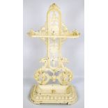 A late Victorian cream painted cast iron stick stand, decorated with a face,