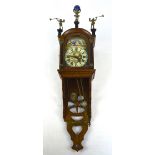 A German oak wall clock with painted arched dial, twin brass weights and rolling moon.
