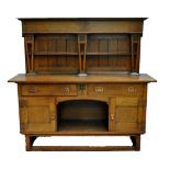 An Arts and Crafts oak dresser with boarded two shelf plate rack,
