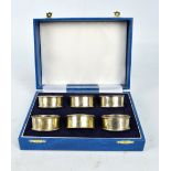 SWATKINS GROUP LTD; a cased set of Elizabeth II hallmarked silver napkin rings, Birmingham 1991.