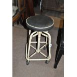 A vintage spring tubular framed cream painted stool with adjustable black leather seat,