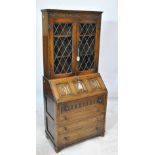 An early 20th century oak bureau base with leaded glazed upper section,