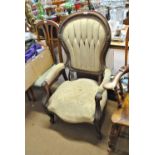 A Victorian mahogany cream upholstered spoon back armchair.