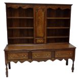 A George III style oak dresser, the plate rack centred with a cupboard door and drawer,