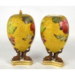 A pair of egg shaped vases decorated with blackberries on a textured gilt ground,