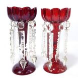 A pair of Victorian cranberry glass table lustres, each with eight prisms, height 26cm.