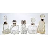 Five variously hallmarked silver mounted clear cut glass scent bottles to include a tapering
