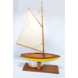 A 20th century wooden pond yacht with rigging, painted in yellow and cream, length 54.