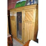 A late Victorian ash three door compactum wardrobe with moulded cornice and painted detail,
