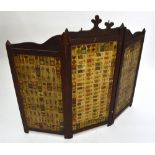 An early 20th century folding oak fire screen decorated with military cigarette cards,