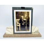 An Art Deco style French marble mounted photograph frame raised on rectangular plinth, width 34.5cm.