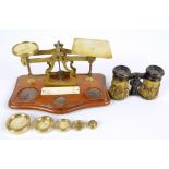 A set of brass postal scales on a shaped oak plinth and a pair of embossed brass opera glasses in