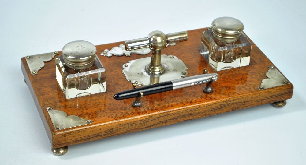 An early 20th century rectangular oak ink stand with silver plated mounts,