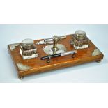 An early 20th century rectangular oak ink stand with silver plated mounts,