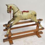 A Tri-ang painted wooden dapple grey rocking horse on trestle platform base, length 120cm (af),