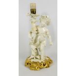 A Moore Bros figural lamp base of a child with gilt painted scrolling base,