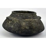 A circular Afghan shallow pot with moulded handled and stylised incised decoration, diameter 27cm.