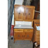 An 1950s oak kitchen unit with pair of cupboard doors above work top,