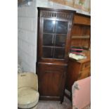 An early 20th century freestanding corner cupboard with glazed upper section, width 54cm.