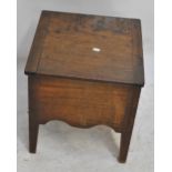 An oak commode with hinged lid and ceramic liner.