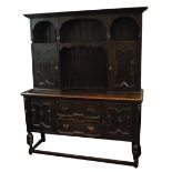 A 1920s oak dresser with moulded cornice and twin cupboard doors above two short drawers flanked by