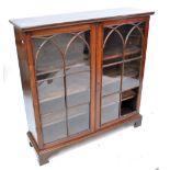 A mahogany two door glazed bookcase with three interior shelves and bracket feet, width 111.5cm.