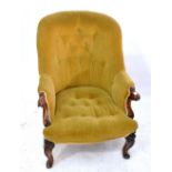 A Victorian mahogany framed armchair with buttoned back and seat and with scroll decorated arm