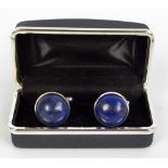 A boxed pair of white metal and lapis lazuli cabochon cufflinks.