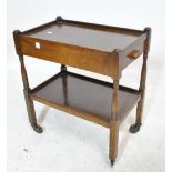 An early 20th century oak two tier trolley on turned and block supports with single drawer to upper