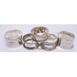 A small collection of hallmarked silver napkin rings comprising a pair of plain form bearing Irish