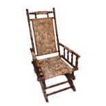 An American oak tapestry upholstered bobbin turned rocking chair.