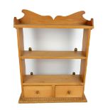 A small pine hanging wall shelf with two base drawers and shaped apron, width 51cm.