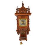 A German oak wall clock with raised pediment,