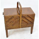 A 1940s sewing box with three hinged stepped drawers, on four square tapering legs, length 50cm.