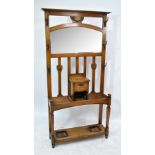 A late 19th/early 20th century Arts and Crafts style oak hall stand with mirror above central