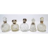 Five variously hallmarked silver mounted clear cut glass scent bottles to include a hobnail cut