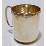 A George V hallmarked silver christening mug of plain form with linear rim, maker mark rubbed,