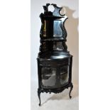 An Edwardian ebonised mahogany corner freestanding display cabinet with broken swan neck pediment