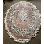 An oval pink ground Chinese superwash carpet, 250 x 160cm.