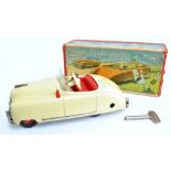 A boxed Schuco 'Radio 4012' musical clockwork cream coloured car, length 15.5cm, with key.