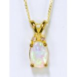 A 9ct yellow gold opal pendant suspended on a fine link chain.