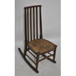 A late 19th century oak slat back rush seated rocking chair, and an oak child's Windsor chair (2).
