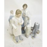 Three Nao figures; a male and female doctor and a girl carrying a rabbit,