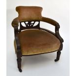 A late Victorian mahogany and upholstered tub chair with ring turned front supports to castors.