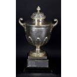 A George V hallmarked silver twin handled trophy cup with domed cover, scrolling handles,