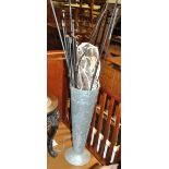 Equestrian interest; a metal stick stand containing a collection of varying whips and crops,